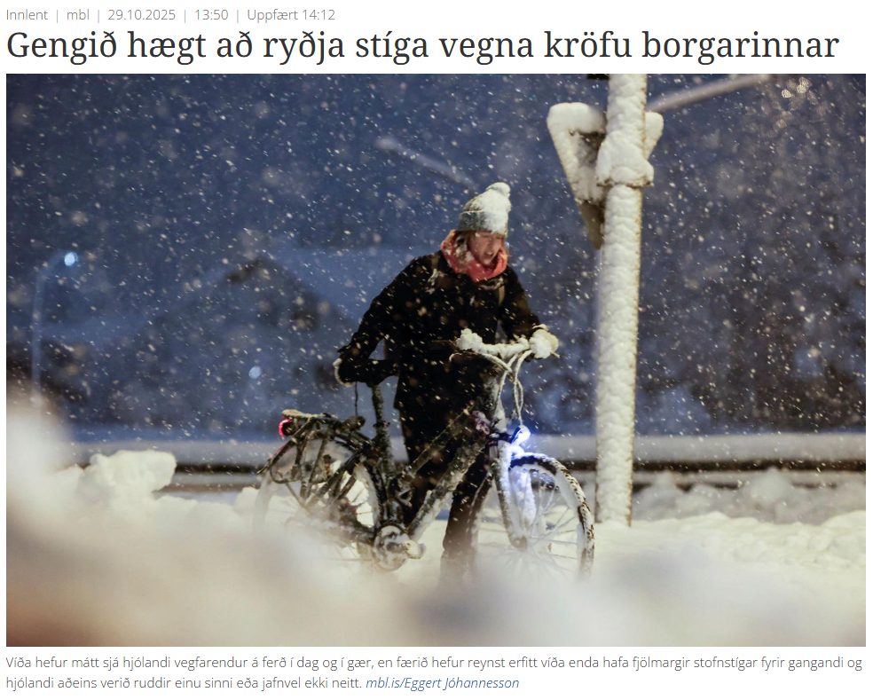Maður á reiðhjóli í snjó á óruddum stíg.